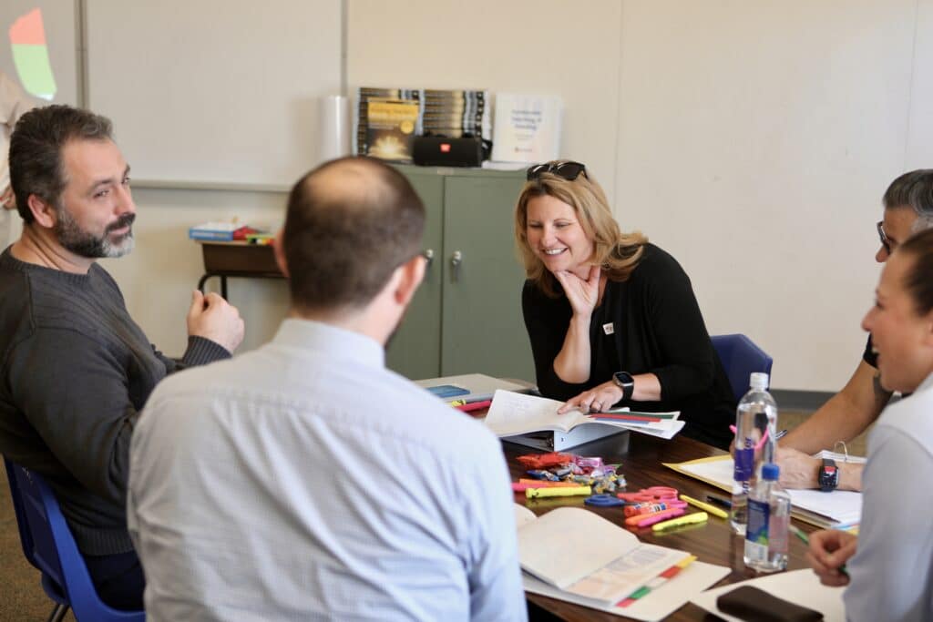 District leaders collaborating around a table during an Orenda workshop